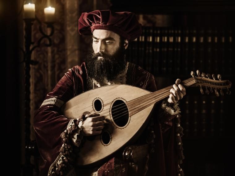 A bearded man in Renaissance clothes playing a lute